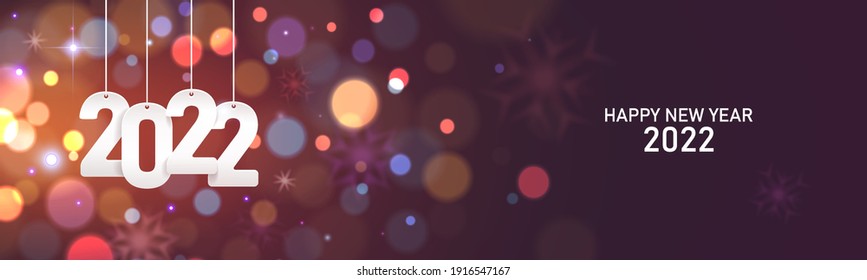 Happy new year 2022. Hanging white paper number on a horizontal defocused colorful blurry background.