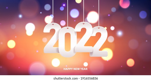 Happy new year 2022. Hanging white paper number on a colorful blurry background.