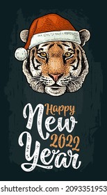 Happy New Year 2022 lettering. Tiger head dressed Santa Claus hat vintage color engraving illustration on black background.