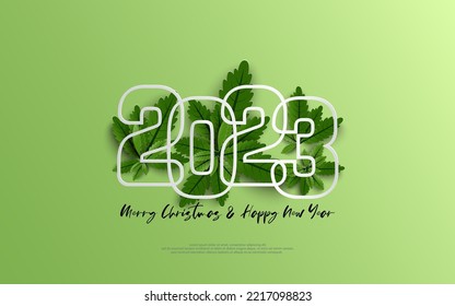 Happy New Year 2023 and merry christmas day. Design number outline on group of green leaves on green gradient background.