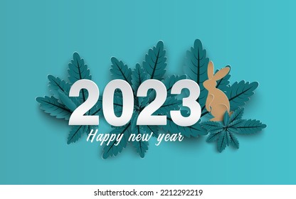 Happy New Year 2023. paper cut of numbers and rabbit on group of blue leaves background.