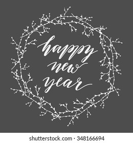 Happy new year greeting card with white wreath and inscription on black background