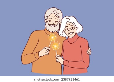 Happy pensioners with sparklers symbolizing christmas stand in embrace together celebrating winter new year holidays. Cheerful gray-haired man and woman using sparklers at festive christmas party