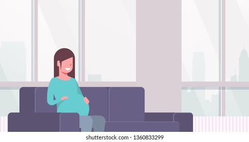 happy pregnant woman sitting on couch girl holding her bump pregnancy and motherhood concept modern home living room interior flat portrait horizontal