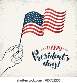 Happy Presidents Day. Man hand holding USA flag with text on retro background. USA Independence Day banner in vintage style.