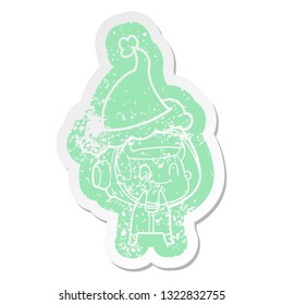 happy quirky cartoon distressed sticker of a astronaut wearing santa hat
