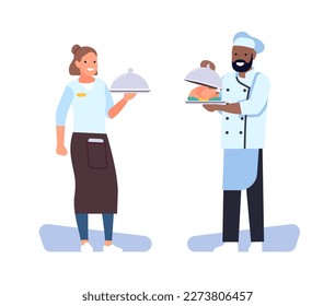 Happy restaurant chef and waitress girl holding metal dish with meal. Cafe staff. Workers in uniform holding food plates. Catering service. Cooking and serving dinner