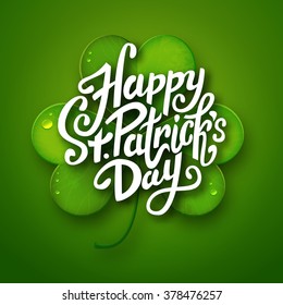 Happy Saint Patrick's Day vector illustration, handwritten brush pen lettering on green realistic shamrock leaf, postcard design