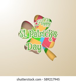 Happy Saint Patrick's Day vector poster on the gradient light brown background, leaf of clover shape cut from carton, pattern with squares of different color, shadow and text.