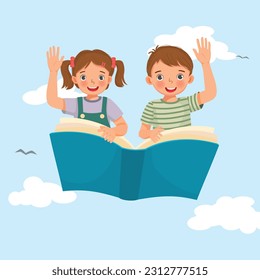 Happy school kids flying on a big open book waving hands in the blue sky 