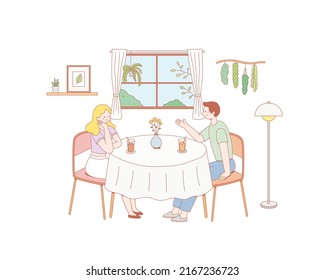 Happy smiling boy and girl sitting at cafe table and talking or chatting. 