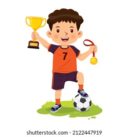 Niño feliz sonriente sostiene medalla de oro y trofeo de ganar partidos de fútbol.