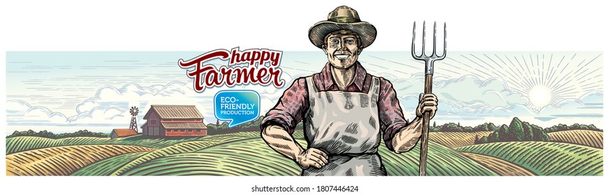 Happy and smiling farmer with a pitchfork in his hands, against the background of an agricultural landscape.