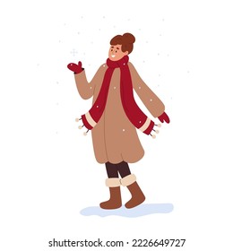 Happy smiling girl enjoying winter weather. Young woman wearing warm coat, scarf, mittens, boots. Female character rejoices in snowfall. Flat cartoon vector illustration