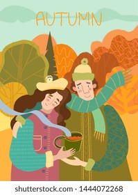 Happy smiling loving couple enjoying hot coffee outdoors as they walk arm in arm through a wooded park in autumn with colorful orange foliage on the trees conceptual of the seasons.