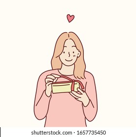 Happy smiling woman holding gift box. Hand drawn style vector design illustrations.