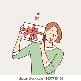 Happy smiling woman holding gift box. Hand drawn style vector design illustrations.