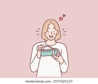 Happy smiling woman holding gift box. Hand drawn style vector design illustrations.	