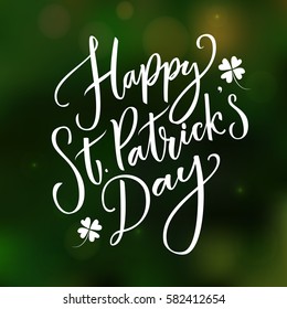 Happy St. Partick's day - greeting card with typography at dark green blurred background.