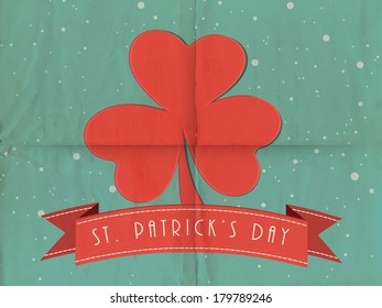 Happy St. Patrick's Day celebration concept with beautiful red shamrock leaf on grungy green background.