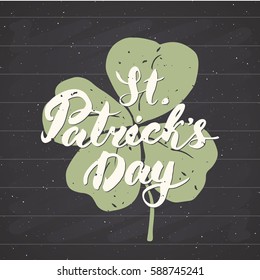 Happy St Patrick's Day Vintage greeting card Hand lettering on clover silhouette, Irish holiday grunge textured retro design vector illustration on chalkboard background