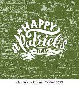 Happy St.Patrick's Day handwritten text. Hand lettering, modern brush calligraphy on brick textured background with ribbon and clover leaf. Vector illustration for greeting card, logo, poster, print