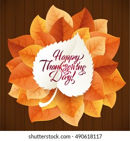 Happy Thanksgiving Day circular ornament made of leaves on wood background. Happy Thanksgiving Day Greeting Card Poster. Thanksgiving Day card template. Happy Thanksgiving banner, flyer.