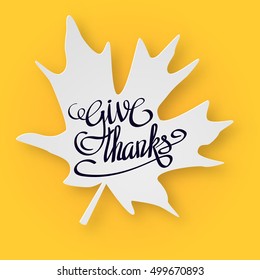 Happy thanksgiving day greeting card with hand lettering on yellow background. Give thanks black text on white maple leaf
