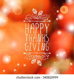 Happy Thanksgiving. Hand sketched graphic vector element with acorns and text on blurred background. 