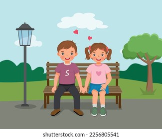 Happy valentine day little couple boy and girl sitting on bench holding hands at the park