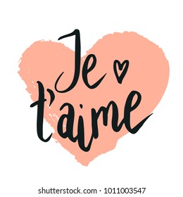 Happy valentine lettering Je t'aime (I love you in French) hand written with dry brush heart shape background.