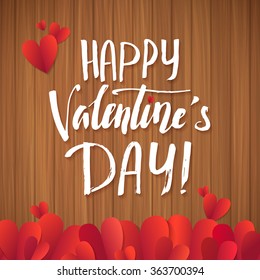 Happy Valentine's Day! Calligraphy white letters on the wooden background with lots of red hearts