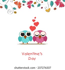 Happy Valentine's Day celebration concept with cute owls couple in love and red hearts.