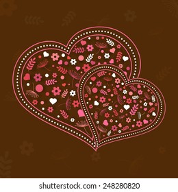 Happy Valentines Day celebration with flowers decorated hearts on brown background.