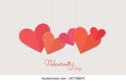 Happy Valentines Day celebration love greeting card decorated by hanging paper folded pink and red hearts.