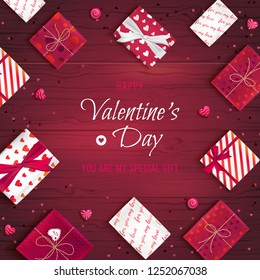 Happy Valentine's Day greeting background. Top view on gift boxes in different packaging, candy lollipops in the form of heart on a wooden table. Festive romantic love web banner. Vector illustration