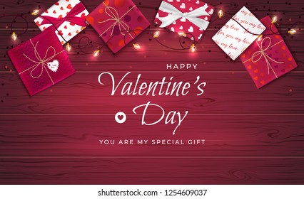 Happy Valentine's Day greeting background. Top view on gift boxes in different packaging, confetti in the form of heart, garland on a wooden table. Beautiful romantic love web banner. Vector 