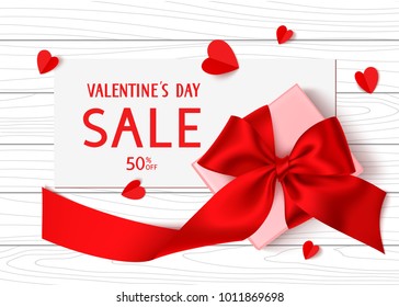 Happy Valentines Day. Holiday Sale template design. Vector background with gift box, red bow, long ribbon and paper hearts. Top view. Paper with SALE text on wooden table and romantic love decorations