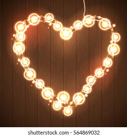 Happy Valentine`s Day. Wood Background with Bright Lights Garland Heart Shape.