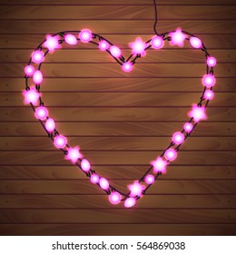 Happy Valentine`s Day. Wood Background with Bright Lights Garland Heart Shape.