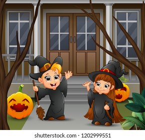 Happy witch couple standing in front of the house