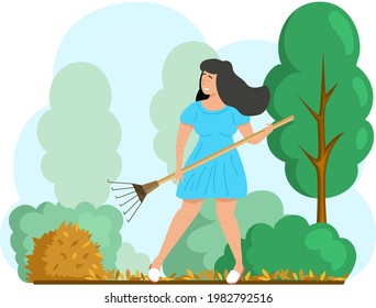 Happy woman doing seasonal garden work, remove leaves with rake, works on yard with trees. Agricultural worker in autumn tidies up garden, removes fallen yellow leaves stands near trees and bushes