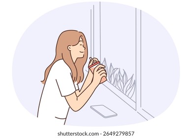 Mulher feliz bebendo suco de copo descartável com palha sentada perto da janela no café e desfrutando do clima de verão. Garota positiva está descansando no café e tem prazer do gosto da bebida de fruta
