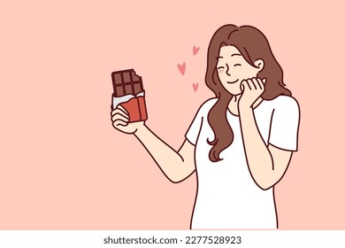 Happy woman enjoying taste of dark chocolate using sweet dessert for snacking and quickly removing hunger. concept of taking milk chocolate with sugar content to fight diabetes and increase insulin 