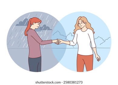 Happy woman and girl suffering from mental disorder stand under sunny and rainy sky. Empathy demonstrated by positive young lady holding hand of victim of mental depression needing psychotherapy