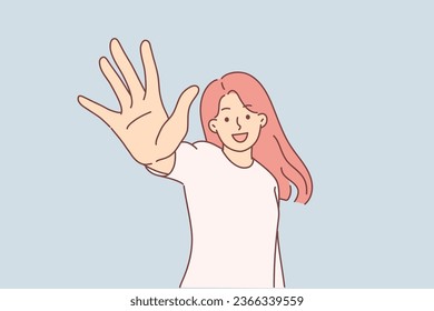 Happy woman holds out hand to screen and says hello or demonstrates number five with fingers. Young girl smiles and wants to share good mood or positive emotions with people around