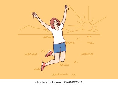 Happy woman jumping walking in summer field with grass and enjoying beautiful natural scenery with sunset. Girl has fun by going to countryside and enjoying freedom or absence of people around