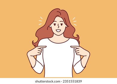 Happy woman pointing finger at t-shirt recommending good laundry detergent or bleach for clothes. Happy girl is proud of own achievements or success in career, and says yes its me.