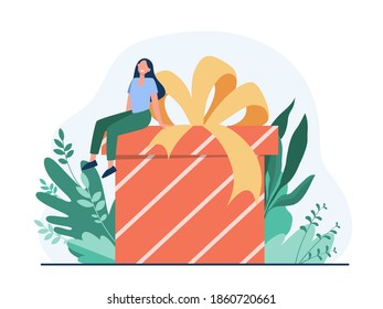 Happy woman receiving gift. Tiny cartoon character sitting on huge present box with bow flat vector illustration. Birthday, surprise, Christmas concept for banner, website design or landing web page