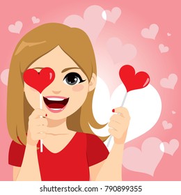 Happy woman smiling holding heart lollipop sticks with hands celebrating Saint Valentine Day